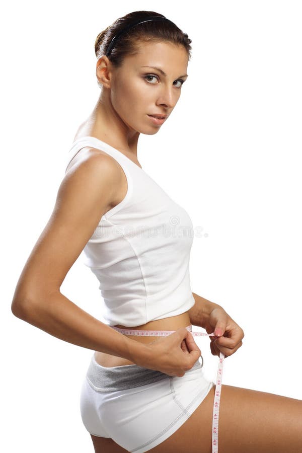 Woman with beautiful body measure her waist by metre-stick looking at camera. Woman with beautiful body measure her waist by metre-stick looking at camera