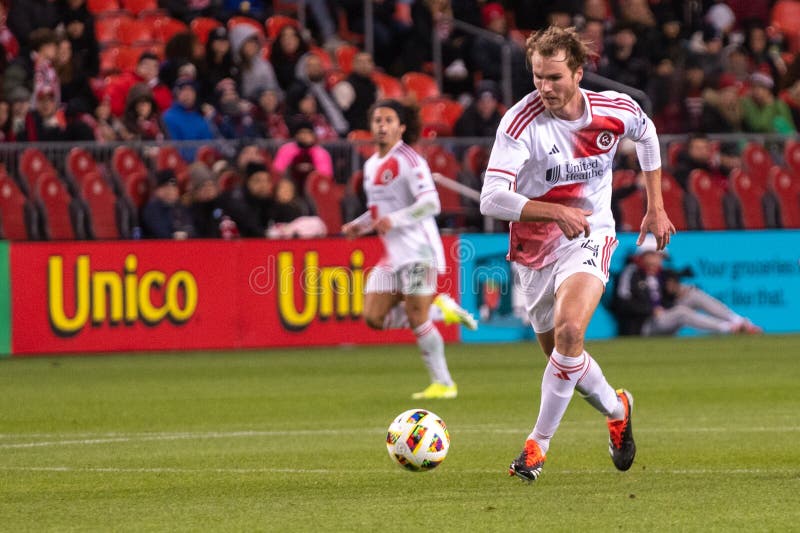 Toronto, ON, Canada - April 20, 2024: Henry Kessler #4 defender of the New England Revolution runs with the ball during the MLS Regular Season match between Toronto FC (Canada) and New England Revolution (USA) at BMO Field. Toronto, ON, Canada - April 20, 2024: Henry Kessler #4 defender of the New England Revolution runs with the ball during the MLS Regular Season match between Toronto FC (Canada) and New England Revolution (USA) at BMO Field