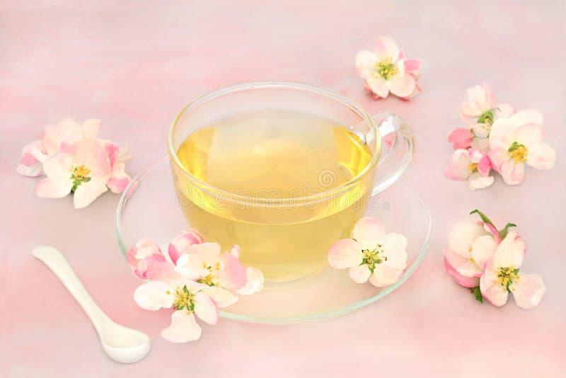 Herb tea hot drink with apple blossom very high in antioxidants and  beneficial for the digestive and nervous systems and skin conditions such as acne and pigmentation. On pink marble. Herb tea hot drink with apple blossom very high in antioxidants and  beneficial for the digestive and nervous systems and skin conditions such as acne and pigmentation. On pink marble.