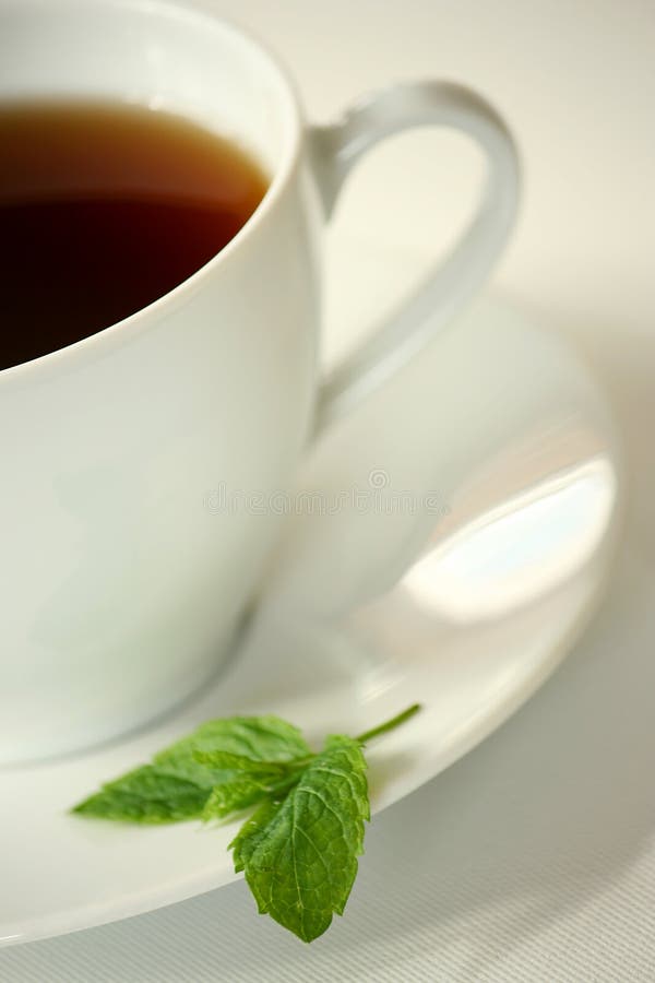 White cup of tea with a mint leaf. White cup of tea with a mint leaf