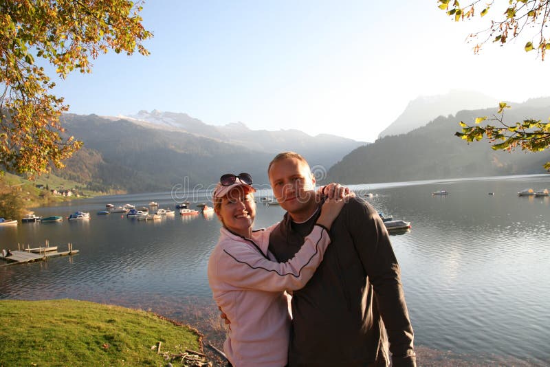 Panoramic view of the lake Wägital in Swiss Alps, the couple relax in the evenings sunrays. Panoramic view of the lake Wägital in Swiss Alps, the couple relax in the evenings sunrays