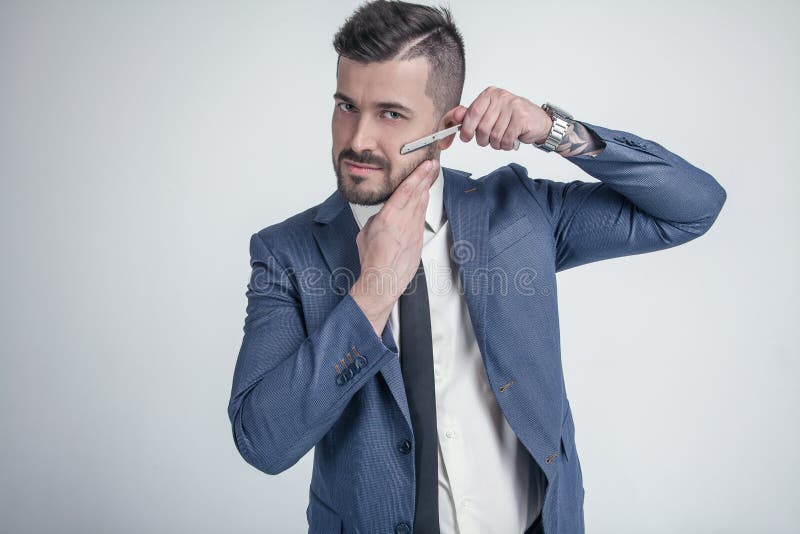 Herenkapper reclameconcept Zakenman met ernstig die gezicht op witte achtergrond wordt geïsoleerd De mens met baard houdt scheerm stock foto's Herenkapper reclameconcept Zakenman met ernstig die gezicht op witte achtergrond wordt geïsoleerd De mens met baard houdt scheerm stock foto's
