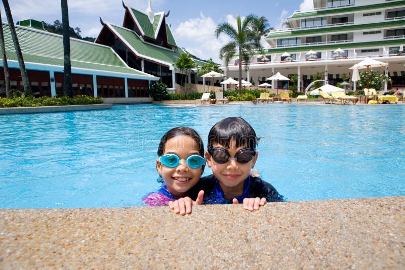 Sister and brother enjoying the resort hotel swimming pool in the tropics. Sister and brother enjoying the resort hotel swimming pool in the tropics