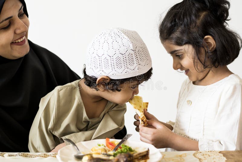 Hermano feeing de la hermana en una cena de la familia imagenes de archivo Hermano feeing de la hermana en una cena de la familia imagenes de archivo
