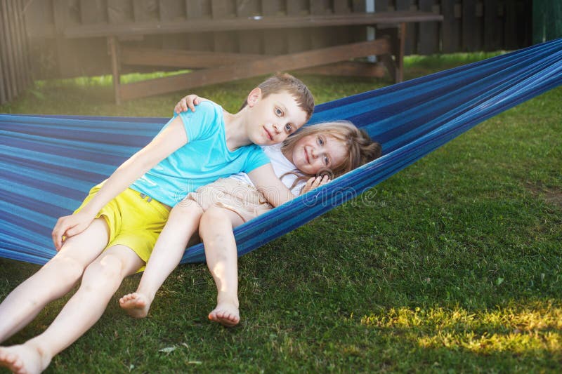 Hermano y hermana niños descansando en el jardín en una hamaca fotografía de archivo libre de regalías