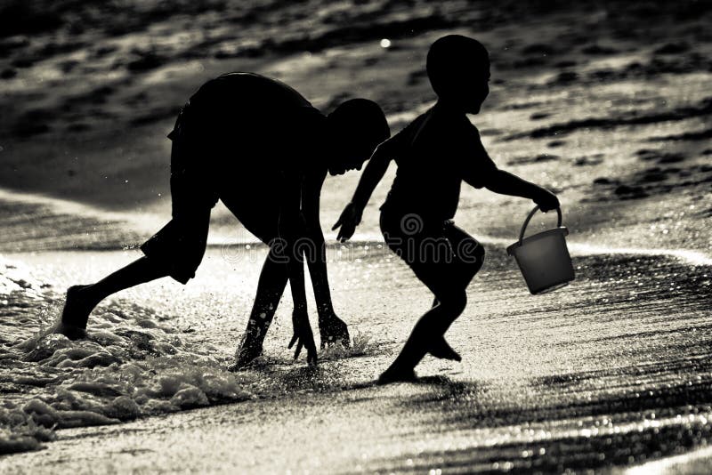 Hermanos de los hermanos que juegan la cogida en una playa en Singapur fotografía de archivo libre de regalías Hermanos de los hermanos que juegan la cogida en una playa en Singapur fotografía de archivo libre de regalías