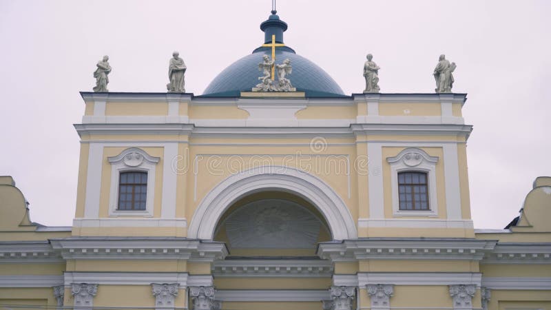 Hermosa fachada de una antigua iglesia con cúpula y estatuas en rusia. acción. vista de fondo de la antigua iglesia amarilla con e