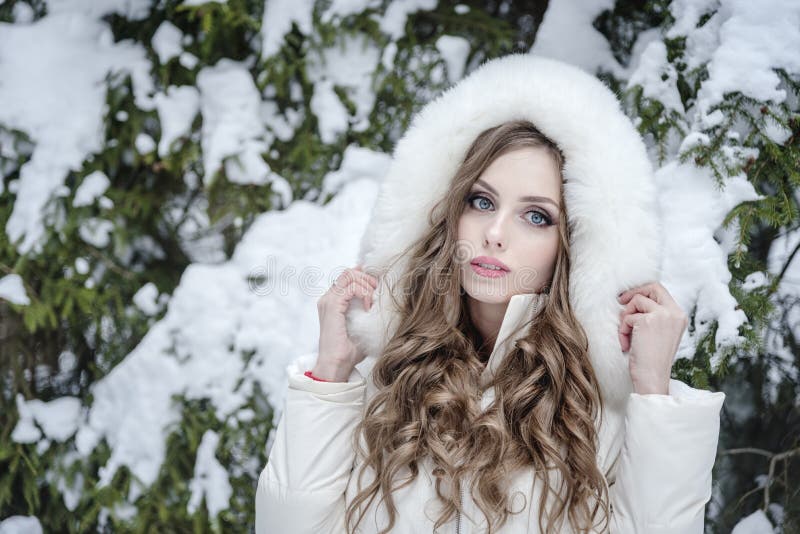 Hermosa joven con una chaqueta de piel en un bosque de invierno nevado foto de archivo libre de regalías Hermosa joven con una chaqueta de piel en un bosque de invierno nevado foto de archivo libre de regalías