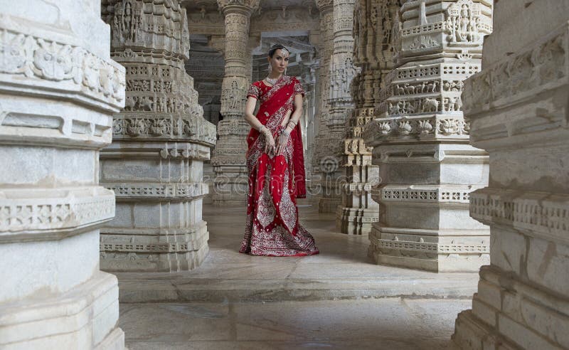 Hermosa joven india vestida de forma tradicional con maquillaje nupcial y joyas orientales imagen de archivo Hermosa joven india vestida de forma tradicional con maquillaje nupcial y joyas orientales imagen de archivo