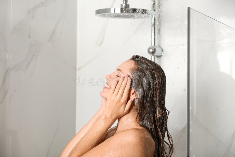 Hermosa joven tomando una ducha en casa imagen de archivo