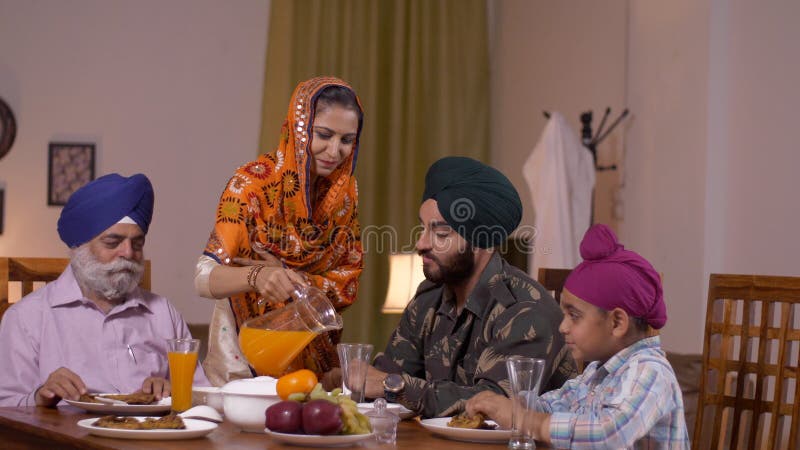Hermosa joven sij sirviendo jugo a sus familiares - amor familiar Oficial del ejército indio con su hijo, padre y esposa