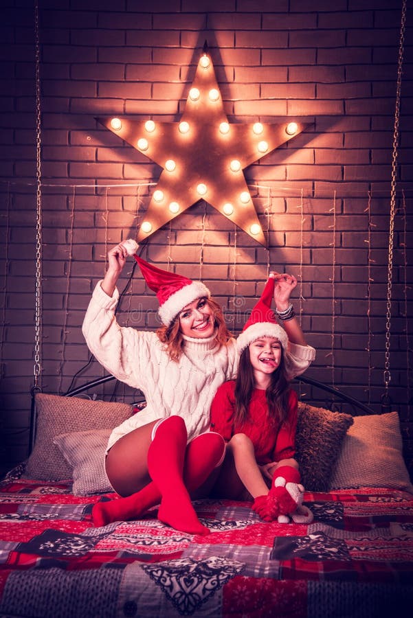 Hermosa mamá e hija en sombreros de Navidad contra iluminación estelar Año Nuevo, 2020, Navidad - concepto foto de archivo