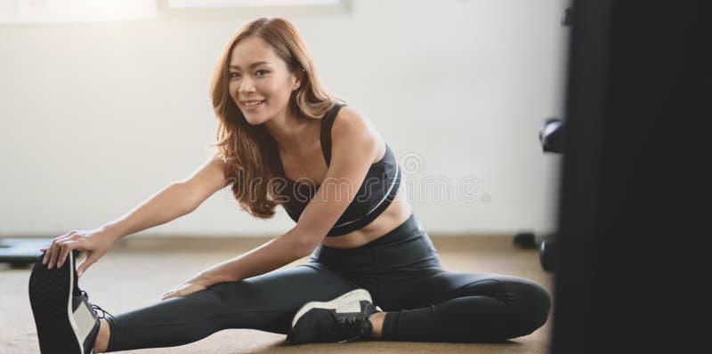 Hermosa mujer asiÃ¡tica con bronceado y piernas delgadas que estiran el cuerpo antes del ejercicio