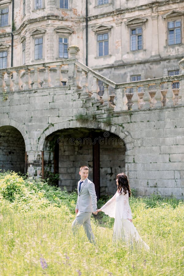 Hermosa pareja de bodas china camina cerca de un viejo edificio, un viejo castillo afuera, un antiguo palacio al aire libre. Incre fotos de archivo libres de regalías Hermosa pareja de bodas china camina cerca de un viejo edificio, un viejo castillo afuera, un antiguo palacio al aire libre. Incre fotos de archivo libres de regalías