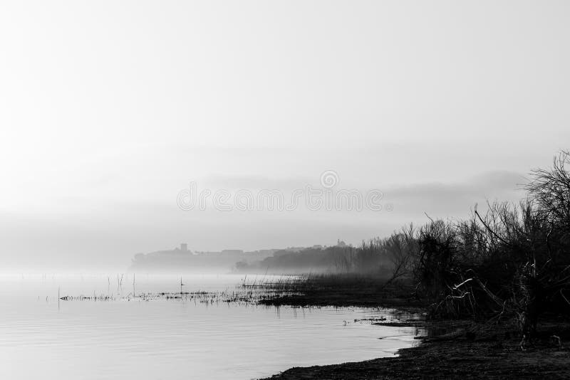 Hermosa vista de la orilla de Umbría del lago Trasimeno en el amanecer, con C fotografía de archivo libre de regalías Hermosa vista de la orilla de Umbría del lago Trasimeno en el amanecer, con C fotografía de archivo libre de regalías
