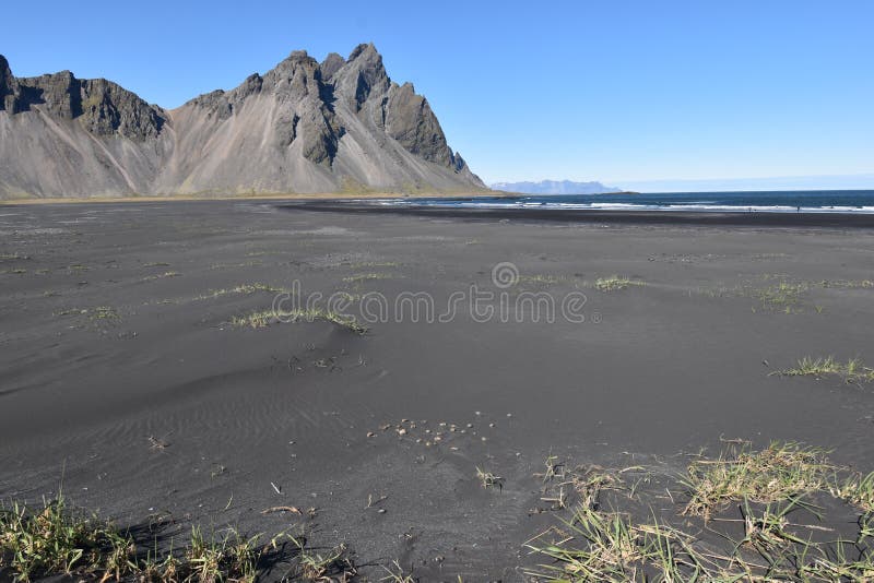Hermosa vista de las montañas de Vestrahorn con la arena negra en frente cerca de Hoefn en Islandia fotografía de archivo Hermosa vista de las montañas de Vestrahorn con la arena negra en frente cerca de Hoefn en Islandia fotografía de archivo
