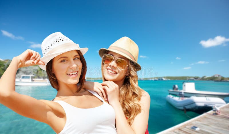 Hermosas mujeres felices con sombreros posando en la playa fotos de archivo libres de regalías