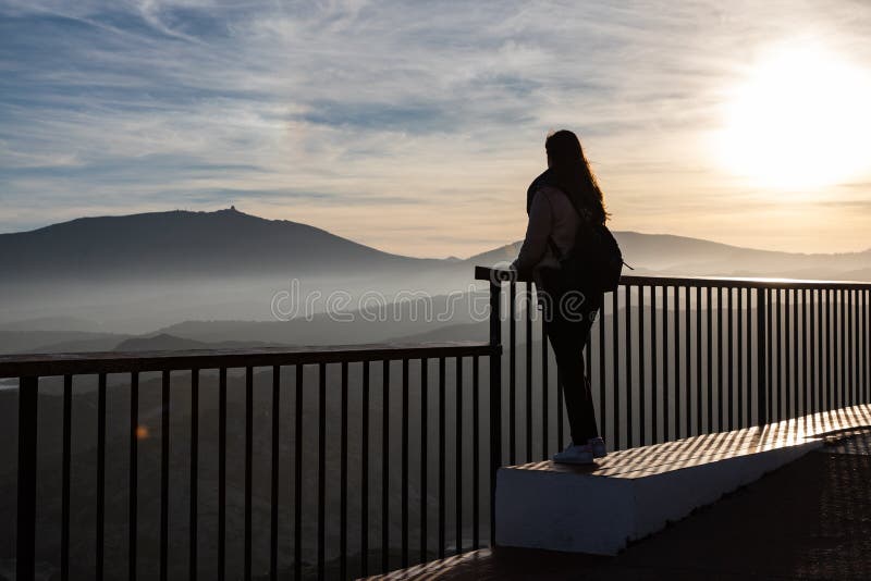 Hermosas mujeres paradas en un mirador en un acantilado durante la puesta de sol foto de archivo libre de regalías