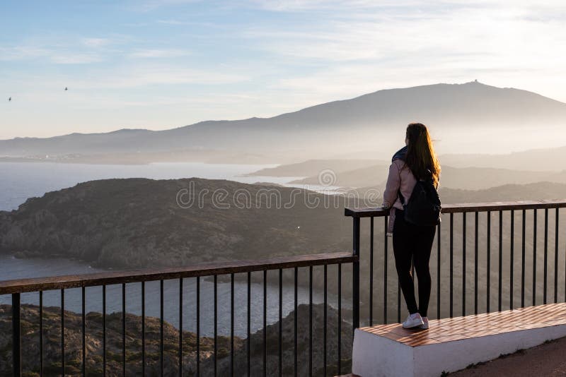 Hermosas mujeres paradas en un mirador en un acantilado durante la puesta de sol fotografía de archivo libre de regalías