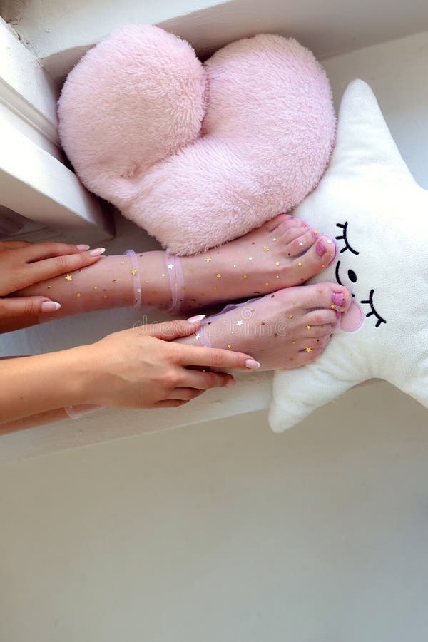 Beautiful groomed woman`s feet in the socks with stars. Care about nails and clean, soft, smooth body skin. Pedicure and manicure beauty salon. Beautiful groomed woman`s feet in the socks with stars. Care about nails and clean, soft, smooth body skin. Pedicure and manicure beauty salon