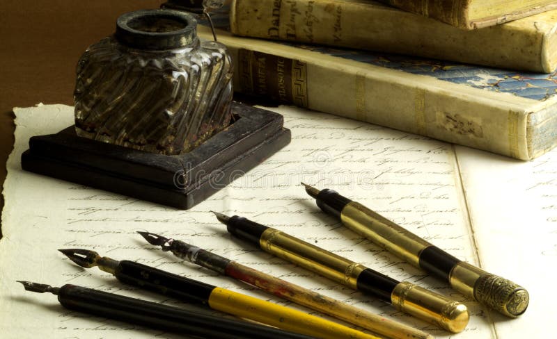 Old ink pot, fountain pens and nibs, old document and old books. Old ink pot, fountain pens and nibs, old document and old books.