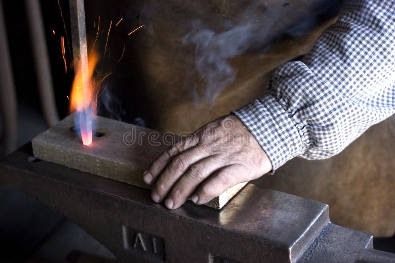 Blacksmith demonstrating how to drill holes in wood. Blacksmith demonstrating how to drill holes in wood.