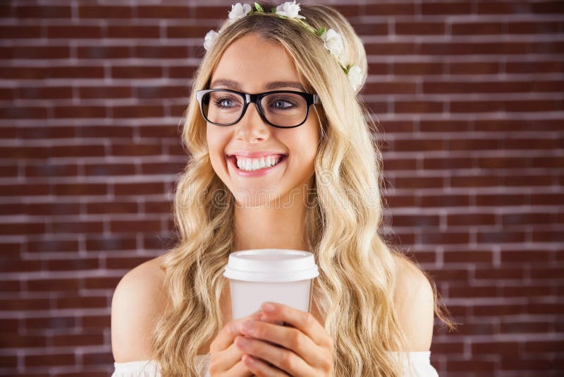 Herrlicher lächelnder blonder Hippie mit Blumenstirnband und Kaffee lizenzfreies stockbild Herrlicher lächelnder blonder Hippie mit Blumenstirnband und Kaffee lizenzfreies stockbild
