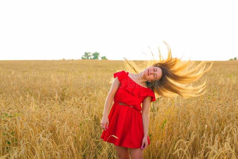 Herrliches romantisches Mädchen draußen Schönes Modell im kurzen roten Kleid auf dem Gebiet Langes Haar, das im Wind durchbrennt lizenzfreies stockfoto Herrliches romantisches Mädchen draußen Schönes Modell im kurzen roten Kleid auf dem Gebiet Langes Haar, das im Wind durchbrennt lizenzfreies stockfoto