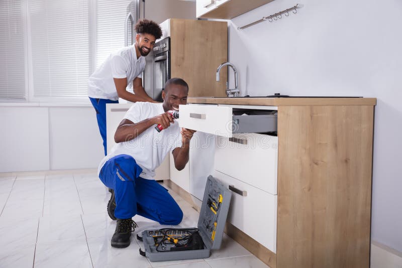 Herstellers die het Houten Kabinet in de Keuken bevestigen stock afbeeldingen Herstellers die het Houten Kabinet in de Keuken bevestigen stock afbeeldingen