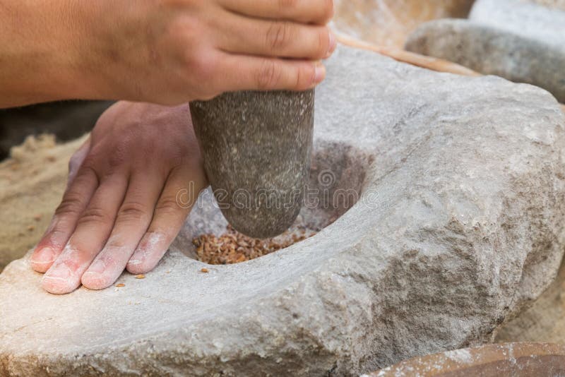 Making flour with stones in a traditional way for the Neolithic era. Making flour with stones in a traditional way for the Neolithic era.