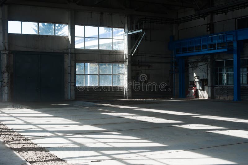Herstellungs-Fabrik Leeres Hangargebäude Blauer getonter Hintergrund Der Produktionsraum mit großen Fenstern und Metallbauten lizenzfreie stockbilder Herstellungs-Fabrik Leeres Hangargebäude Blauer getonter Hintergrund Der Produktionsraum mit großen Fenstern und Metallbauten lizenzfreie stockbilder