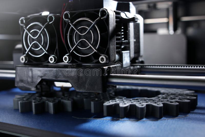 Herstellungsstirnräder FDM 3D-printer vom Silber-grauen Faden auf Blaupausenband im hellen Licht