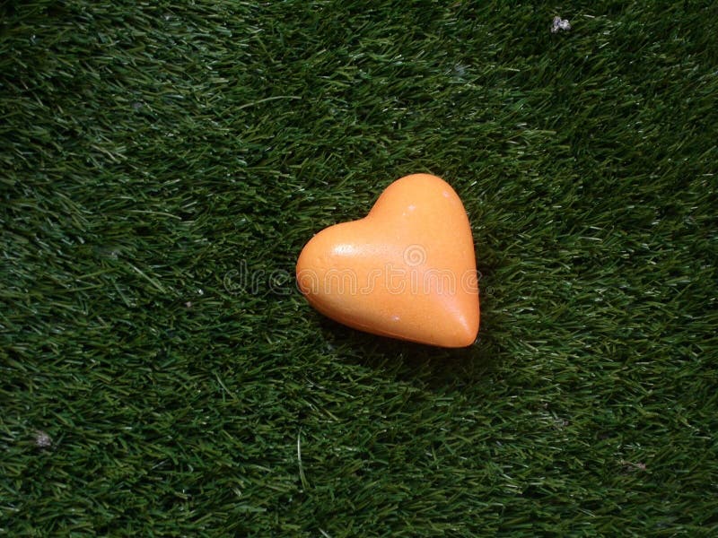 Herz in der Orange auf Hintergrund des grünen Grases lizenzfreie stockfotos Herz in der Orange auf Hintergrund des grünen Grases lizenzfreie stockfotos