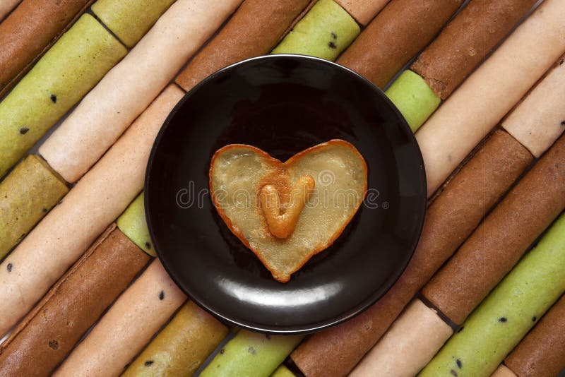 Herz formte Pfannkuchen mit Innere des Buchstaben V auf dunkelbrauner Platte stockbild Herz formte Pfannkuchen mit Innere des Buchstaben V auf dunkelbrauner Platte stockbild