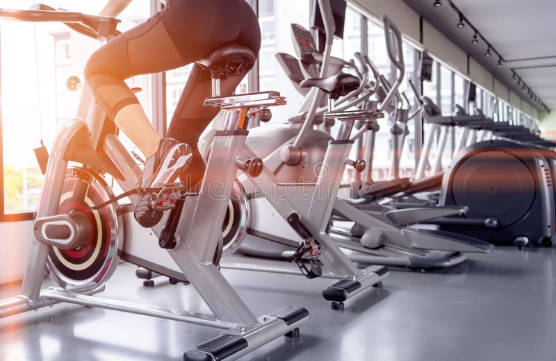 Exercise bike cardio workout at fitness gym of woman taking weight loss with machine aerobic for slim and firm healthy in the morning. Exercise bike cardio workout at fitness gym of woman taking weight loss with machine aerobic for slim and firm healthy in the morning