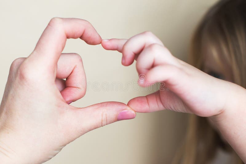 Herzform wurde von den Händen der kleinen Mädchen und ihren Mutterhänden auf beige Hintergrund stockbilder