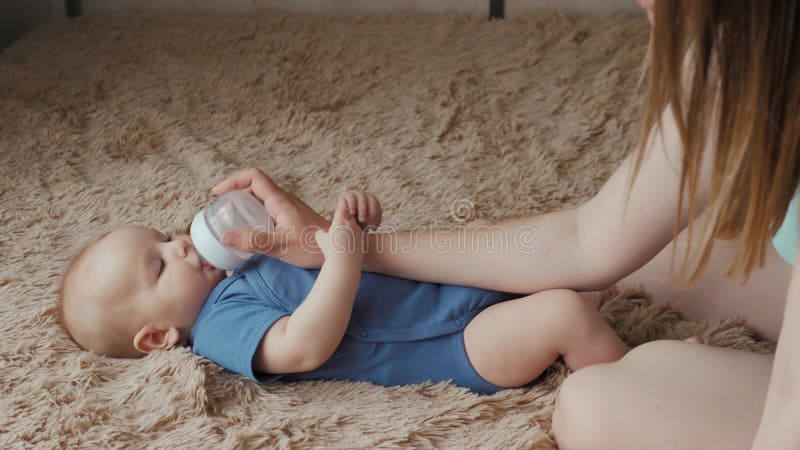 Het aanbiddelijke drinkwater van de kindbaby van fles Het meisje of de jongen drinkt water in bed