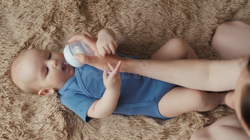 Het aanbiddelijke drinkwater van de kindbaby van fles Het meisje of de jongen drinkt water in bed