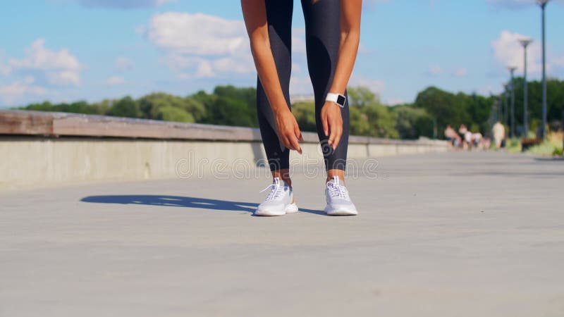 Het aanhalen van sneakers door vrouwen en het buiten lopen