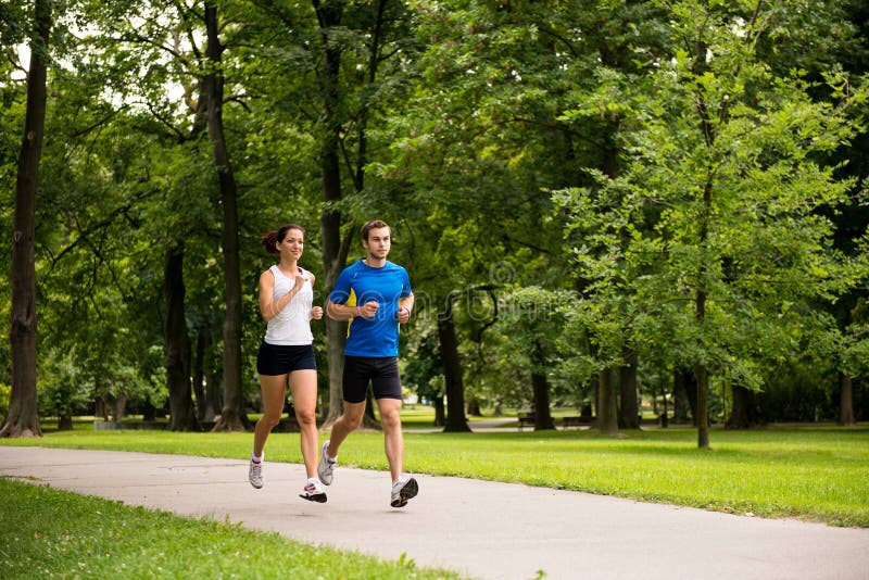 Het aanstoten samen - het jonge paar lopen royalty-vrije stock foto's Het aanstoten samen - het jonge paar lopen royalty-vrije stock foto's