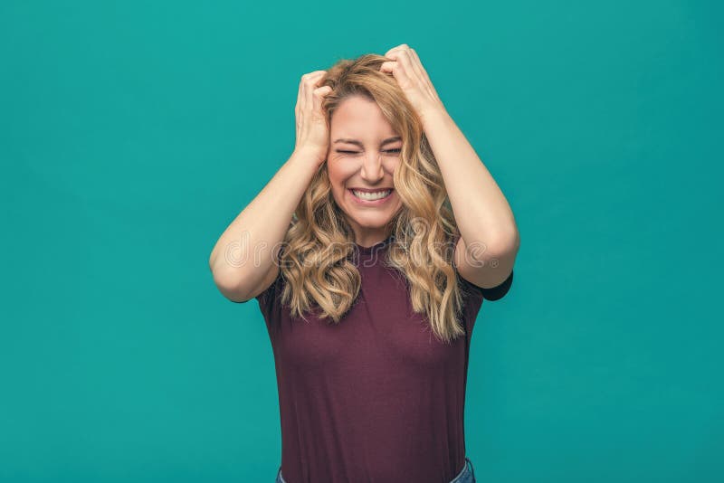 Het aantrekkelijke boze blondemeisje houdt boos haar hoofd Boze jonge vrouw op blauwe achtergrond royalty-vrije stock foto Het aantrekkelijke boze blondemeisje houdt boos haar hoofd Boze jonge vrouw op blauwe achtergrond royalty-vrije stock foto