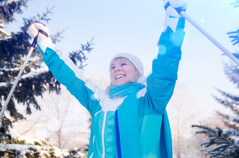 Het aantrekkelijke glimlachende blonde geniet van een skigang in het de winterbos stock foto Het aantrekkelijke glimlachende blonde geniet van een skigang in het de winterbos stock foto
