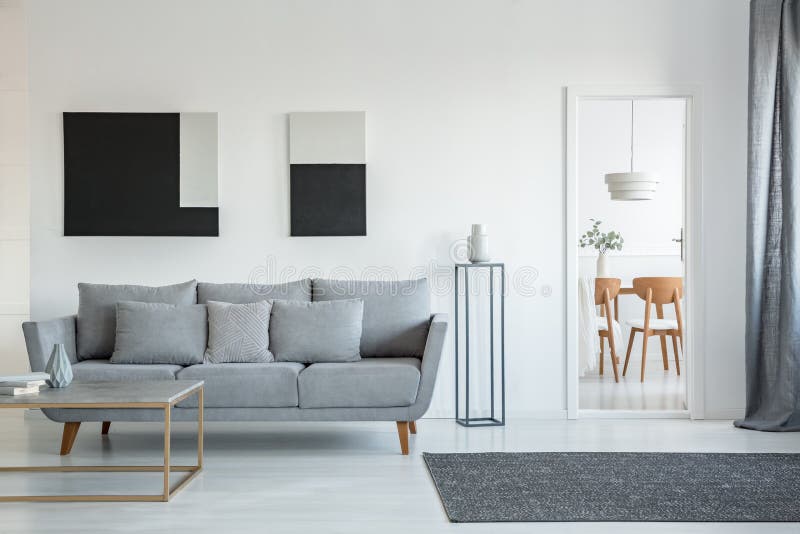 Het abstracte zwart-witte schilderen op lege muur van modieus woonkamerbinnenland met comfortabele grijze laag met hoofdkussens royalty-vrije stock afbeeldingen Het abstracte zwart-witte schilderen op lege muur van modieus woonkamerbinnenland met comfortabele grijze laag met hoofdkussens royalty-vrije stock afbeeldingen