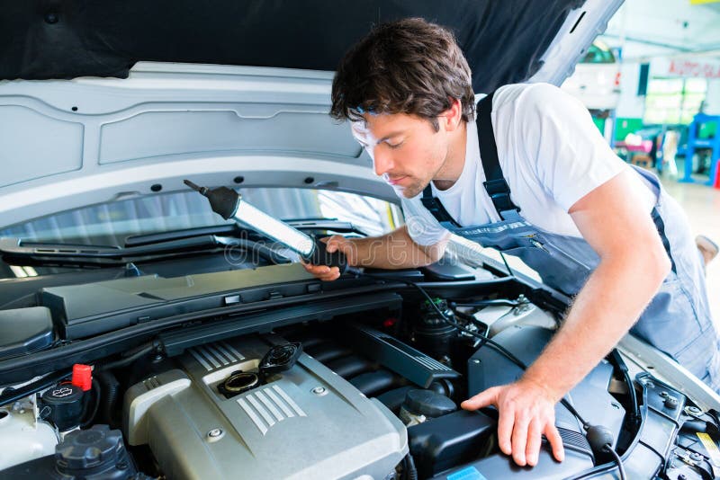 Het auto mechanische werken in de workshop van de autodienst stock afbeeldingen Het auto mechanische werken in de workshop van de autodienst stock afbeeldingen