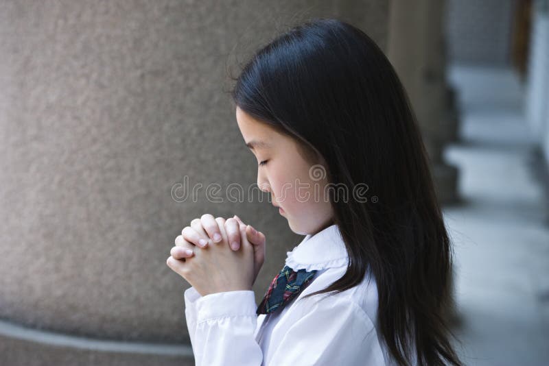 Het Aziatische schoolmeisje bidden stock foto Het Aziatische schoolmeisje bidden stock foto