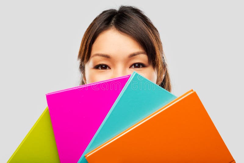 Het Aziatische vrouw of studenten verbergen achter notitieboekjes royalty-vrije stock afbeelding Het Aziatische vrouw of studenten verbergen achter notitieboekjes royalty-vrije stock afbeelding