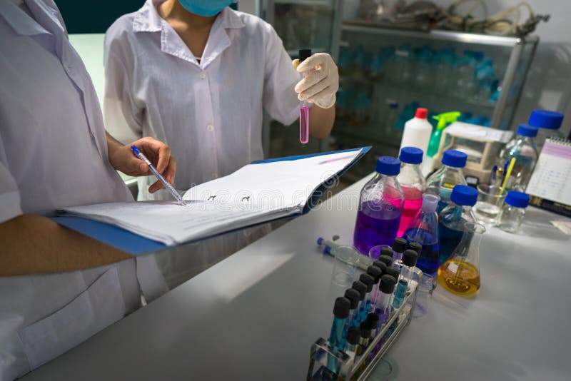 Het Aziatische vrouwelijke wetenschapper neerschrijven nemen van en het testrapport van onderzoek met reageerbuizen in laboratori royalty-vrije stock afbeeldingen Het Aziatische vrouwelijke wetenschapper neerschrijven nemen van en het testrapport van onderzoek met reageerbuizen in laboratori royalty-vrije stock afbeeldingen