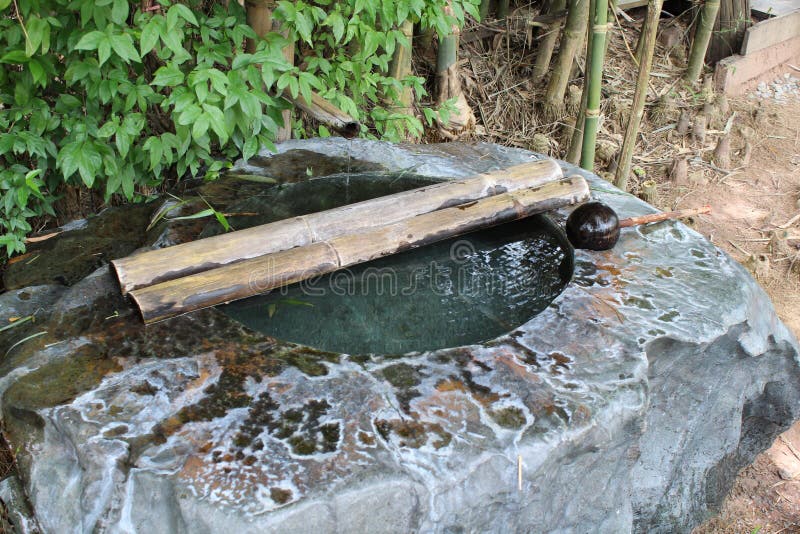 Het bassin van het steenwater met water van bamboepijp royalty-vrije stock afbeeldingen Het bassin van het steenwater met water van bamboepijp royalty-vrije stock afbeeldingen