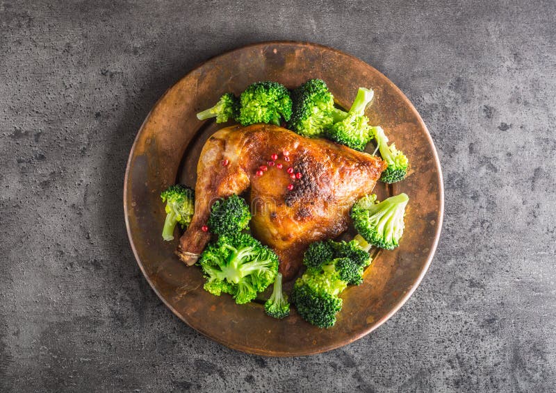 Het been van de braadstukkip Kip geroosterd been met broccoli op beton stock afbeelding Het been van de braadstukkip Kip geroosterd been met broccoli op beton stock afbeelding