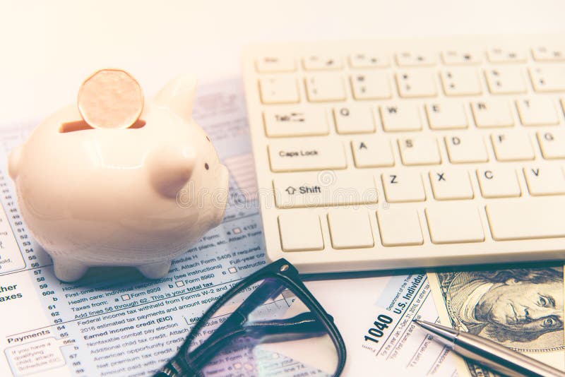 Het berekenen belasting voor inkomensbelastingaangifte voor besparingsbelasting, doel voor sparen muntstuk in het spaarvarken royalty-vrije stock afbeeldingen Het berekenen belasting voor inkomensbelastingaangifte voor besparingsbelasting, doel voor sparen muntstuk in het spaarvarken royalty-vrije stock afbeeldingen